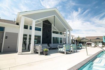 A house with a swimming pool and a patio with chairs